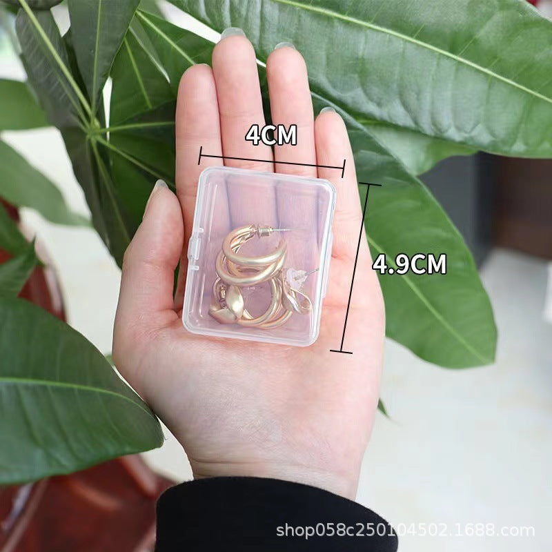 Transparent jewelry storage box with multiple compartments for organizing rings, necklaces, and earrings, by IBG.