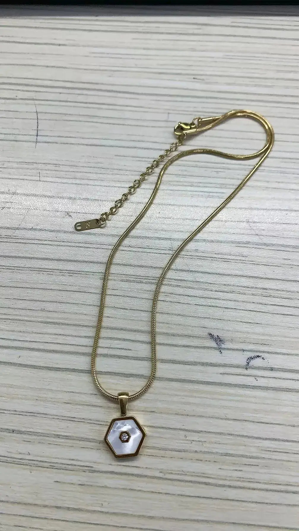 Stainless steel ball chain necklace by IBG, minimal everyday jewelry, close-up of sleek round ball chain design.